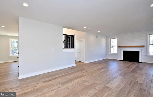 an empty room with wooden floor and fireplace
