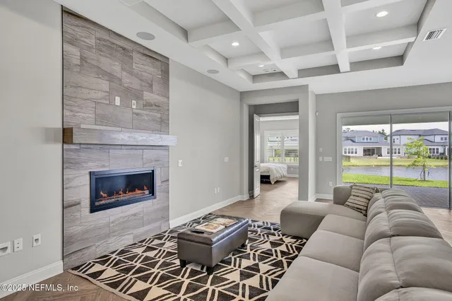 a living room with furniture a fireplace and a floor to ceiling window