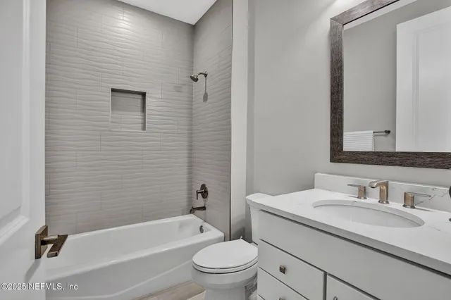 a bathroom with a granite countertop sink a toilet and a bathtub