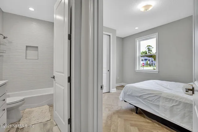 a bedroom with a bed and a painting on the wall