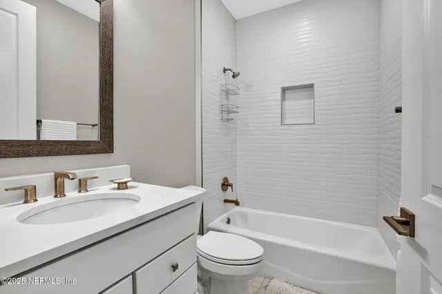 a bathroom with a granite countertop sink a toilet and a bathtub