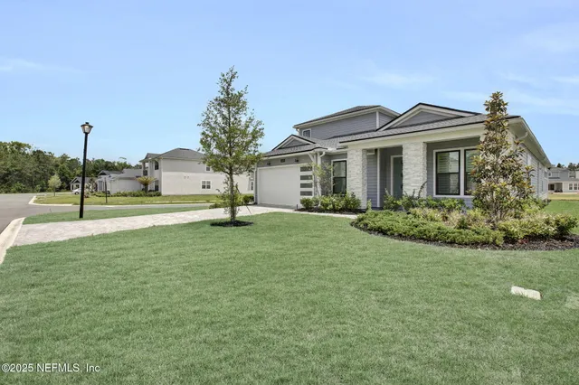 a view of a big house with a big yard and potted plants