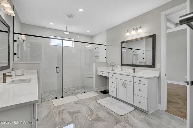 a bathroom with a granite countertop sink mirror and shower