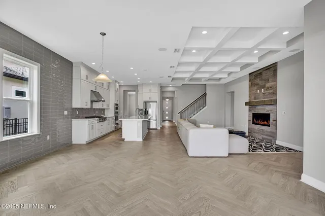 a living room with furniture and kitchen view