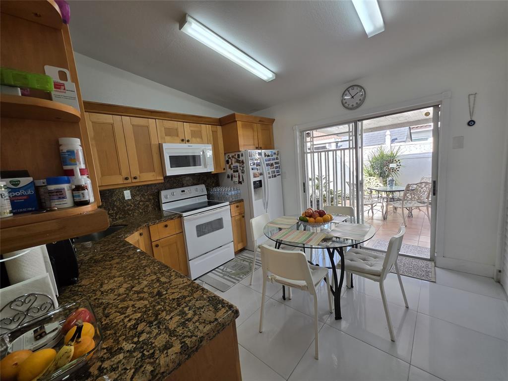 7635 Northwest 181st Street Hialeah, FL 33015 - Photo 8 of 12 a kitchen with a table chairs and a stove