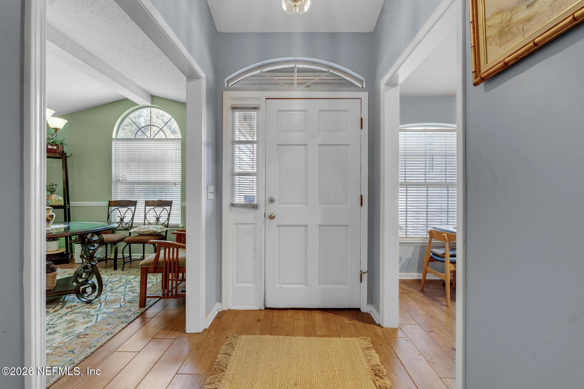 3566 Pond Ridge Court West Jacksonville, FL 32223 - Photo 3 of 13 a view of a hallway with wooden floor and a dining room