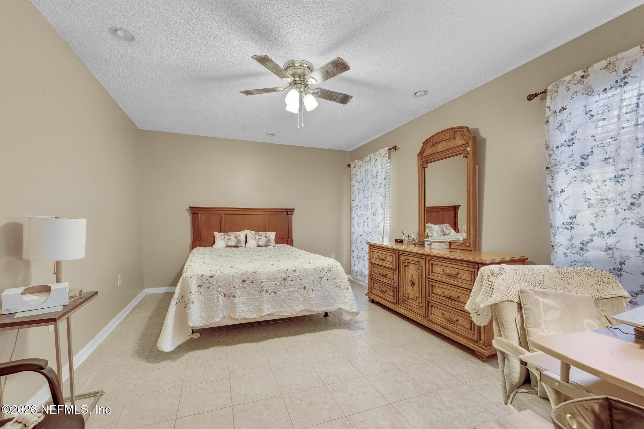 3566 Pond Ridge Court West Jacksonville, FL 32223 - Photo 10 of 13 a bedroom with a bed and a chandelier