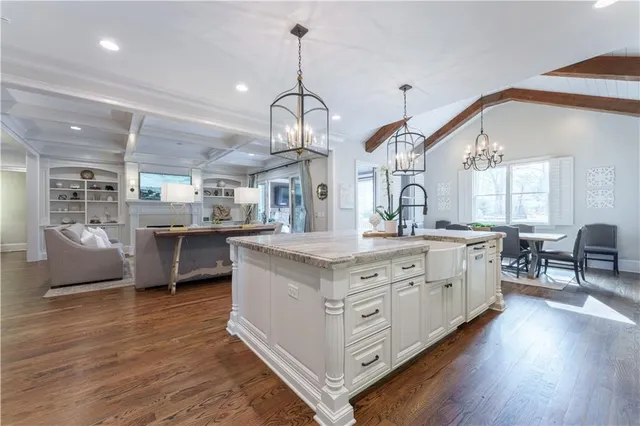 a kitchen with stainless steel appliances granite countertop a sink cabinets and wooden floor