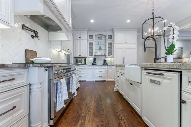 a kitchen with stainless steel appliances a sink stove and cabinets