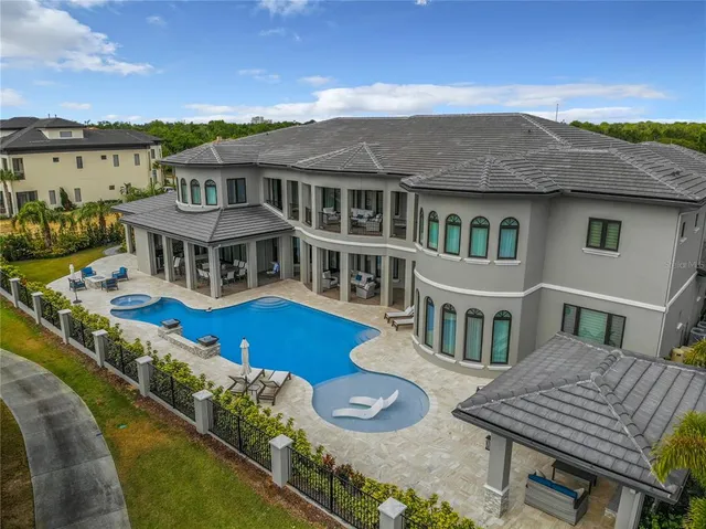 an aerial view of a house with a garden and lake view