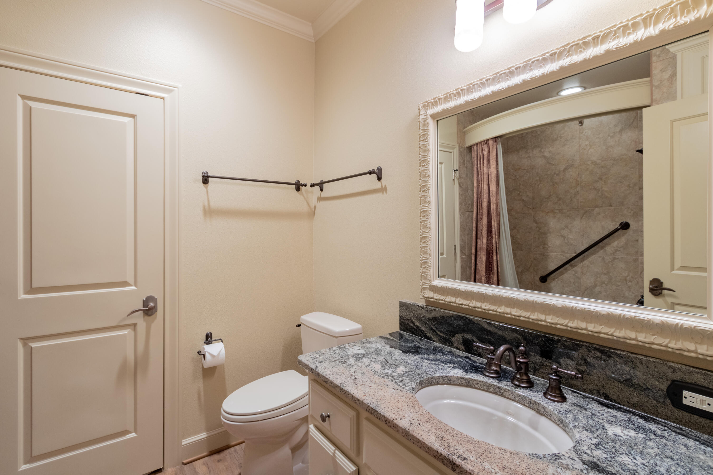 4501 19th Street, Unit 5 Lubbock, TX 79407 - Photo 16 of 52 a bathroom with a granite countertop toilet sink and mirror