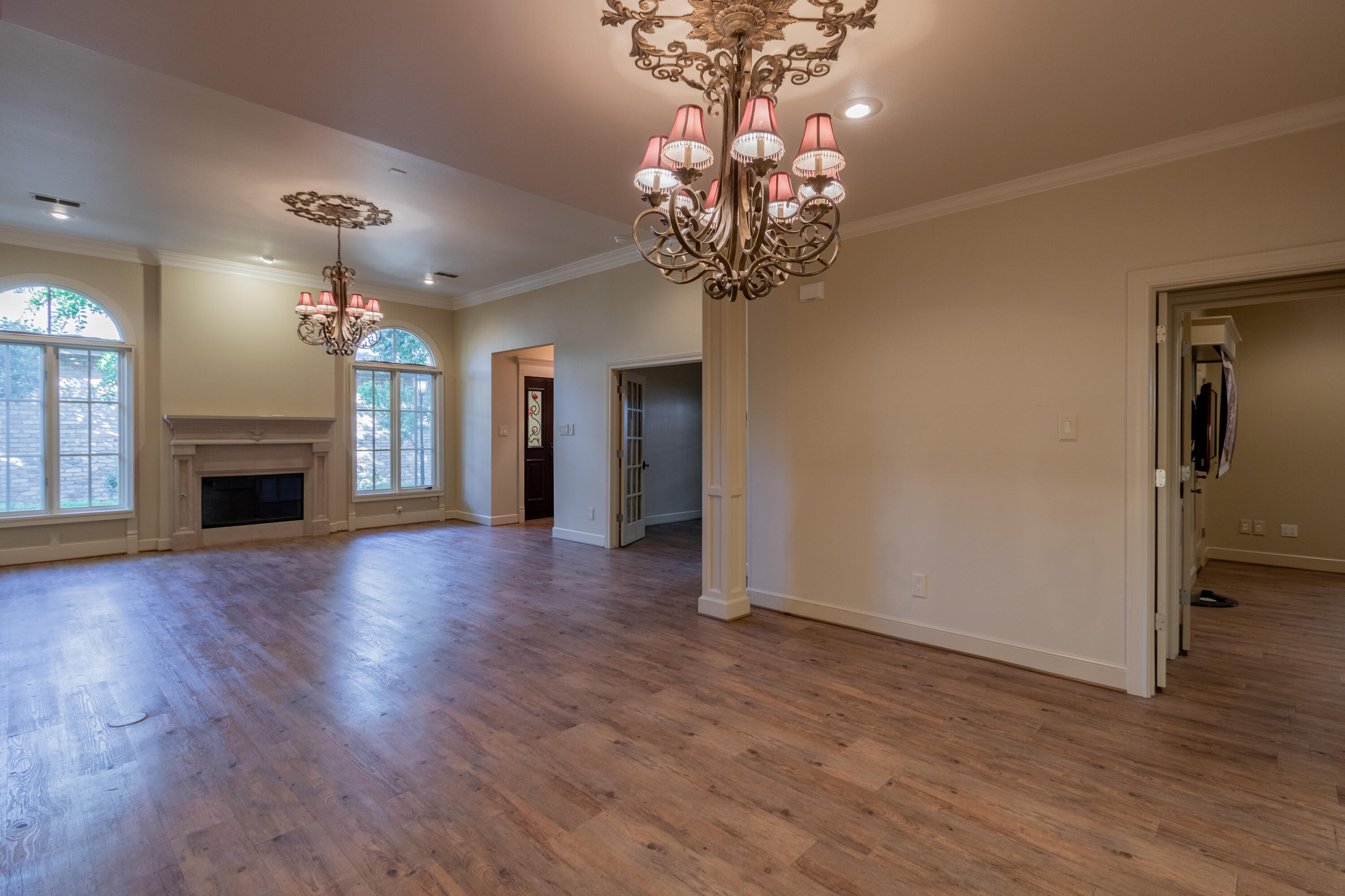 4501 19th Street, Unit 5 Lubbock, TX 79407 - Photo 19 of 52 a view of a livingroom with a fireplace wooden floor and chandelier