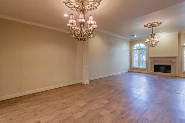 a view of a room with wooden floor and chandelier