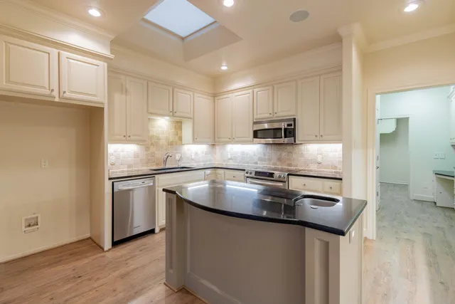 a kitchen with stainless steel appliances granite countertop a sink a stove and a refrigerator