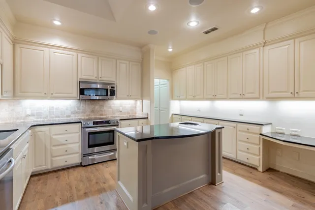 a kitchen with stainless steel appliances granite countertop a sink stove and cabinets