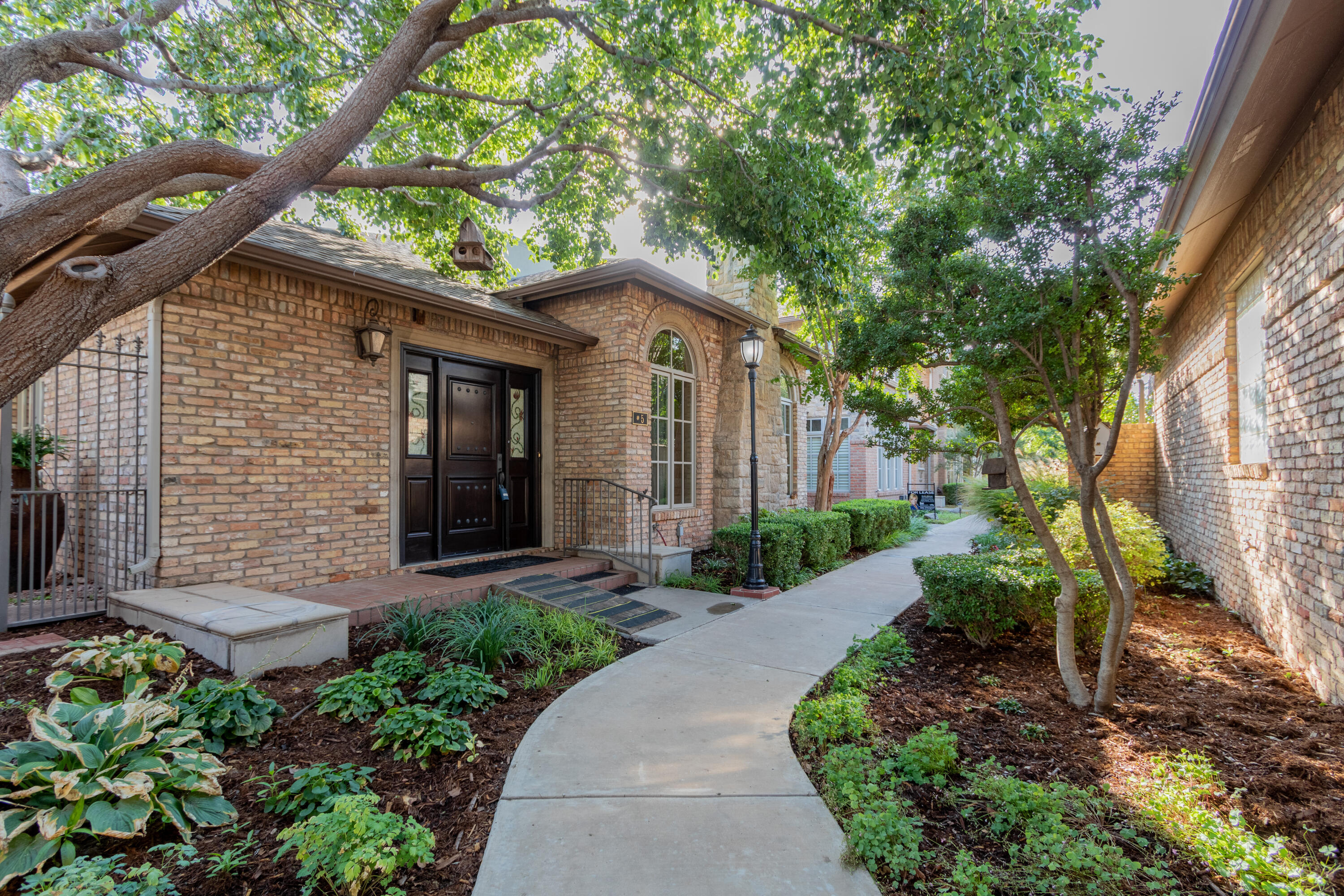4501 19th Street, Unit 5 Lubbock, TX 79407 - Photo 4 of 52 a front view of a house with garden