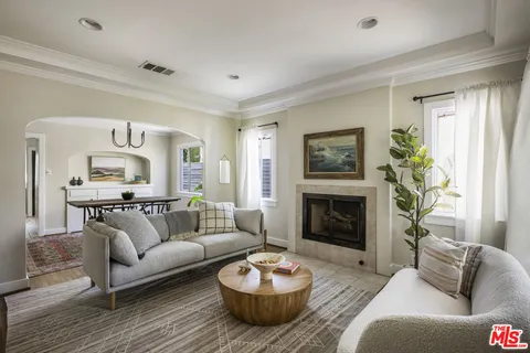 a living room with furniture a fireplace and a window