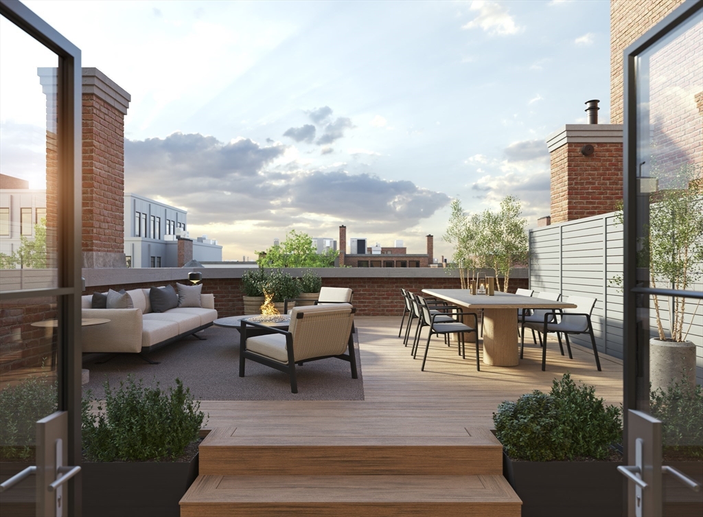 397 Commonwealth Avenue, Unit PH Boston, MA 02215 - Photo 4 of 8 a view of a patio with couches potted plants and a table
