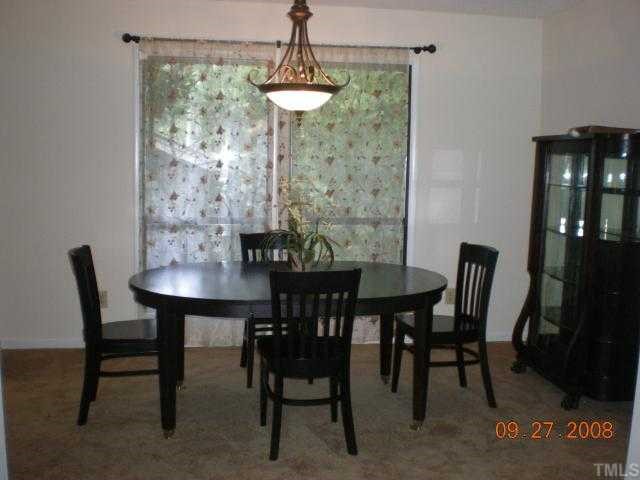 2713 Rue Sans Famille Raleigh, NC 27607 - Photo 5 of 12 a view of a dining room with furniture and chandelier