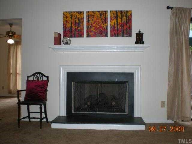 2713 Rue Sans Famille Raleigh, NC 27607 - Photo 8 of 12 a living room with a fireplace and a window