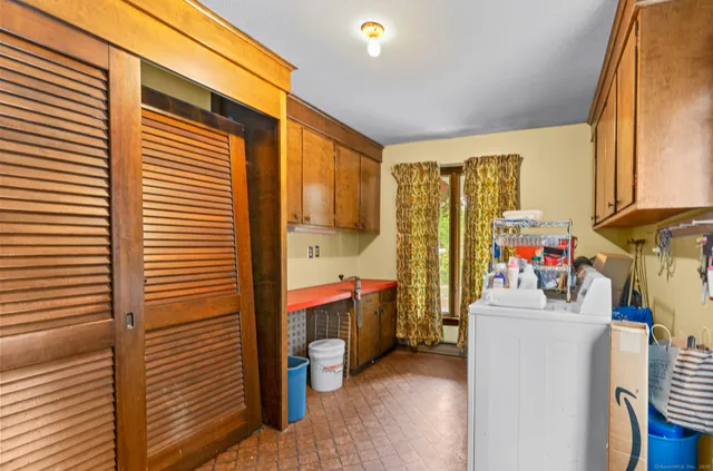 a kitchen with stainless steel appliances a refrigerator a stove a sink dishwasher and a dining table with wooden floor