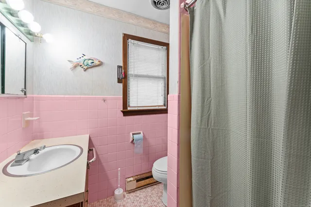 a bathroom with a sink a toilet and a mirror