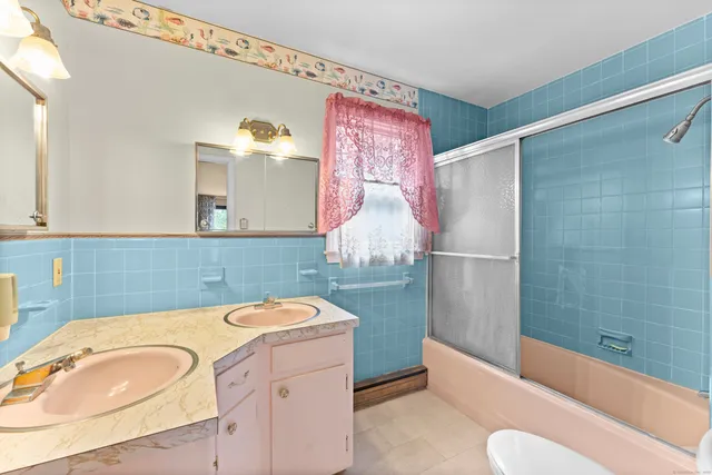 a bathroom with a toilet a sink and mirror