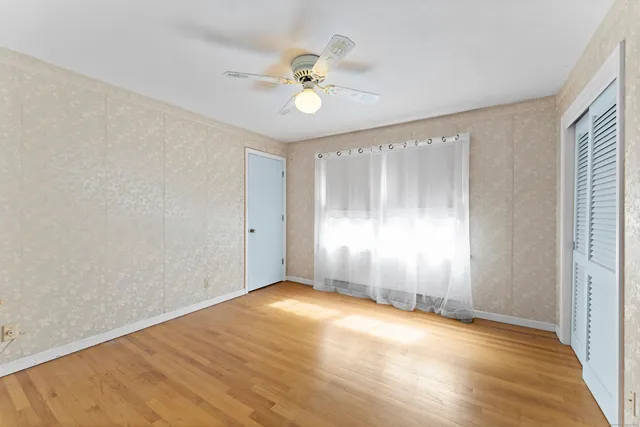 a view of empty room with wooden floor