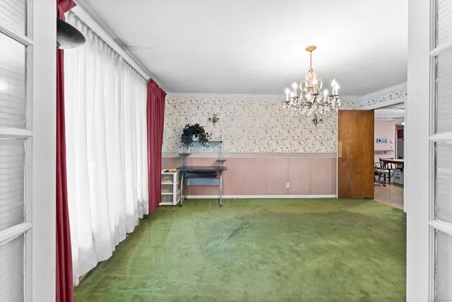 a view of a livingroom with a fireplace a chandelier and stairs