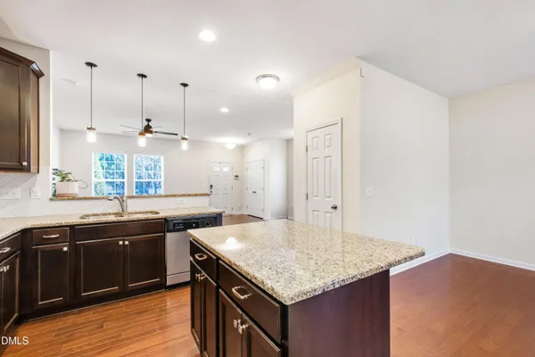 a kitchen with stainless steel appliances granite countertop a sink a stove and a wooden cabinets