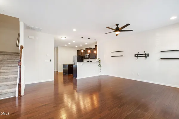 a view of a big room with wooden floor and a ceiling fan