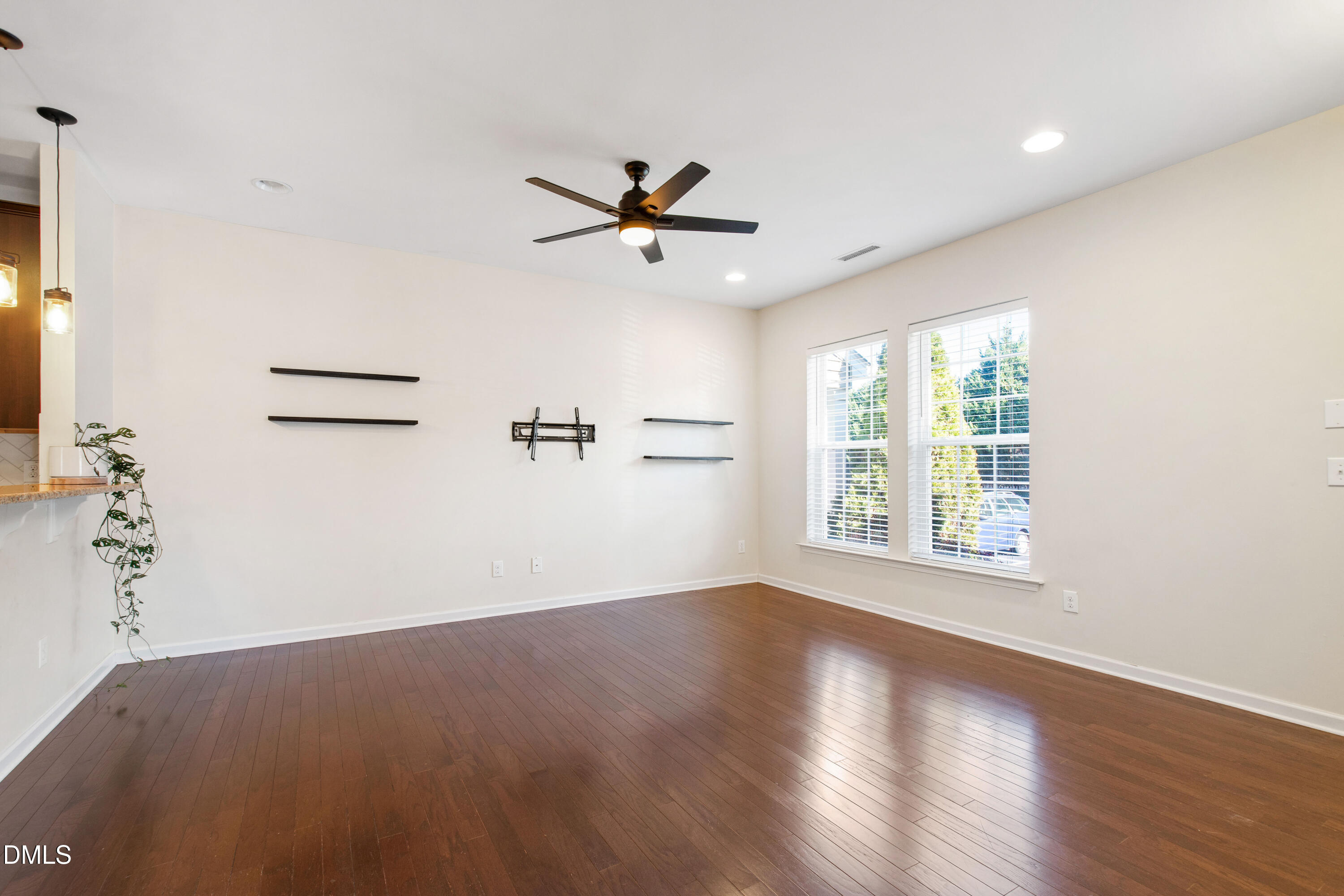 1118 Renewal Place Raleigh, NC 27603 - Photo 5 of 38 an empty room with wooden floor ceiling fan and windows