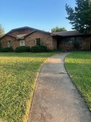 a front view of a house with a garden and yard