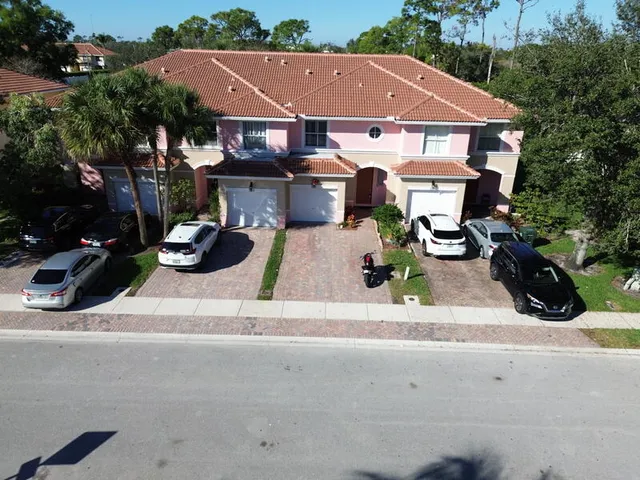 an empty room with a chandelier fan and windows