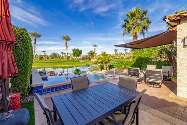 a view of a patio with table and chairs potted plants and palm trees