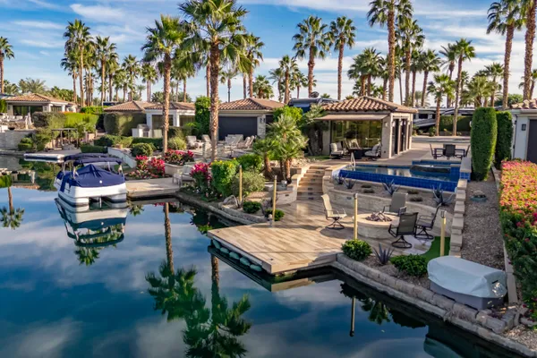a view of a patio with table and chairs potted plants and floor to ceiling window