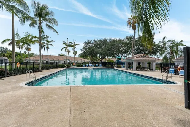 a view of swimming pool with palm trees