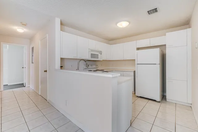 a utility room with cabinets washer and dryer