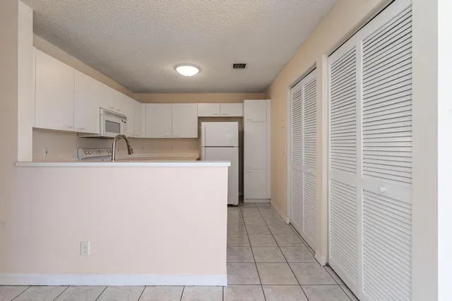 a kitchen with stainless steel appliances granite countertop a sink and a refrigerator