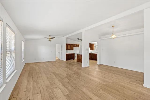 a view of empty room with wooden floor and window