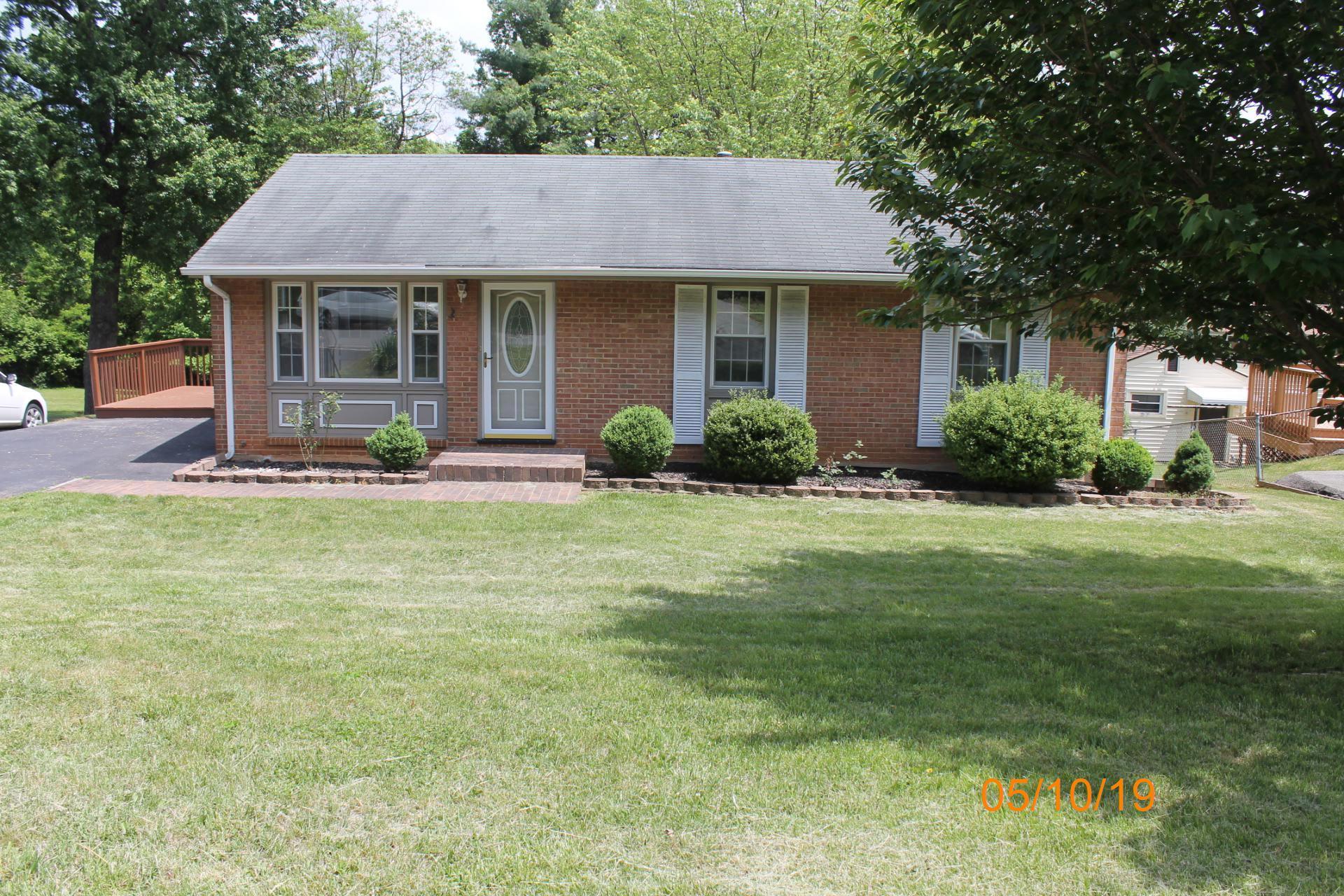 a front view of a house with a yard and trees
