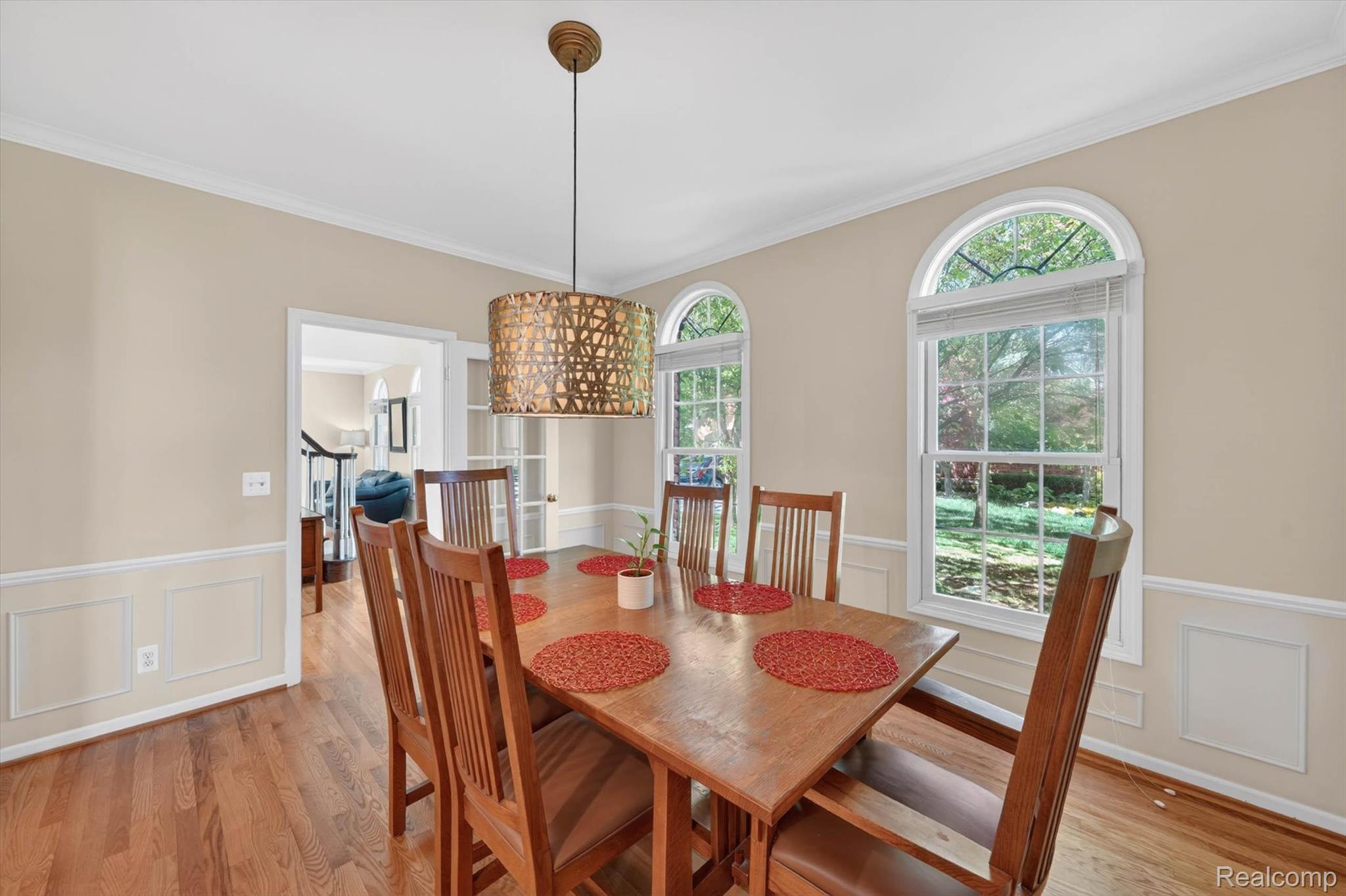 1112 Vernier Road Grosse Pointe, MI 48236 - Photo 16 of 39 Dining room featuring a decorative wall, wainscoting, ornamental molding, light wood-style floors, and plenty of natural light