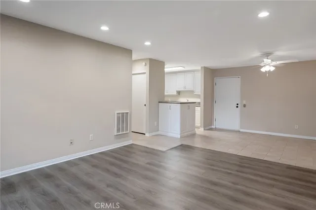 a view of empty room with wooden floor and window
