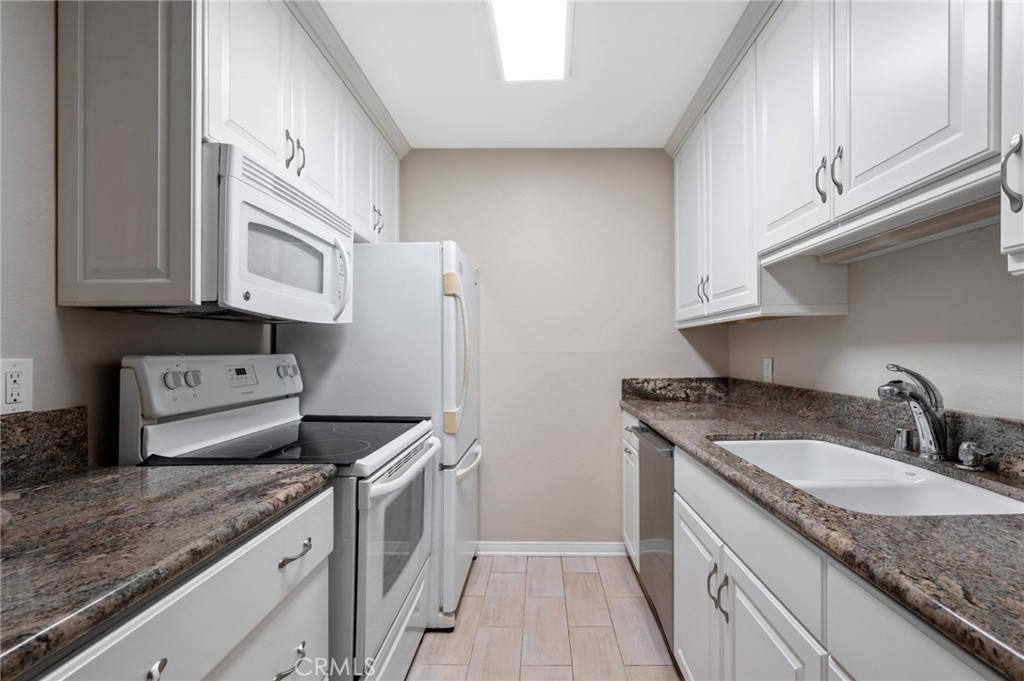 3604 West Estates Lane, Unit 117 Rolling Hills Estates, CA 90274 - Photo 8 of 36 a kitchen with granite countertop a sink stove and refrigerator