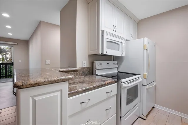 a kitchen with granite countertop cabinets stainless steel appliances and a counter space