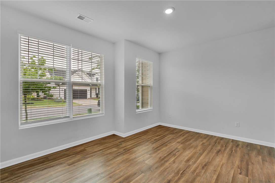 8 Leander Drive Greer, SC 29651 - Photo 4 of 31 Hardwood-style flooring and abundant natural illumination enhance this flexible room.