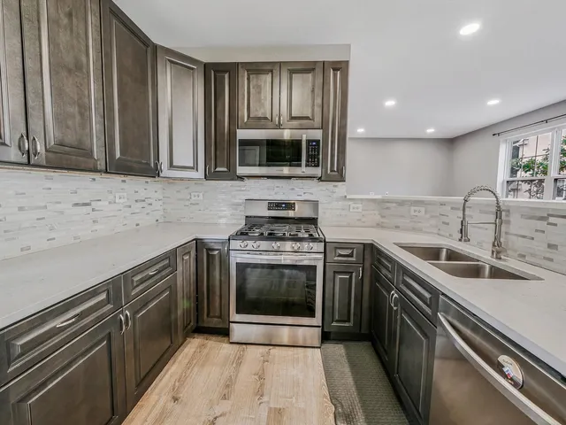 a kitchen with a refrigerator stove and wooden cabinets