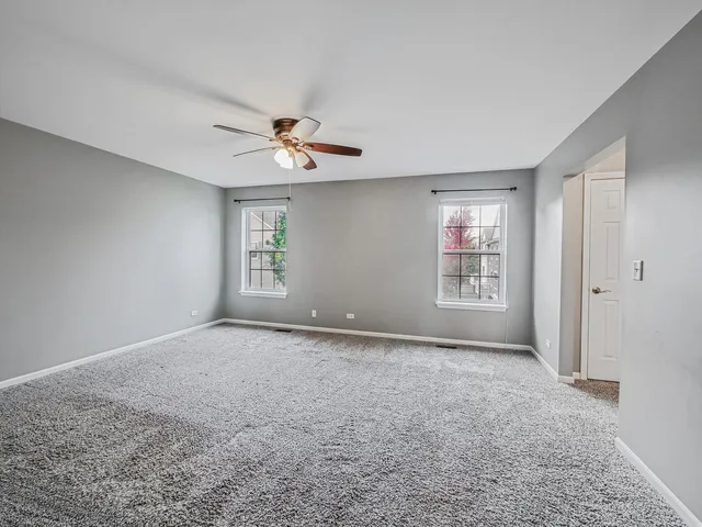 a view of a room with a ceiling fan and a window
