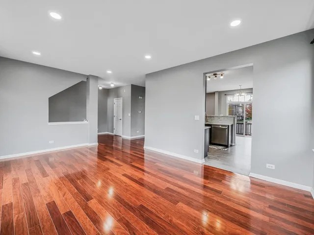 a view of empty room with wooden floor