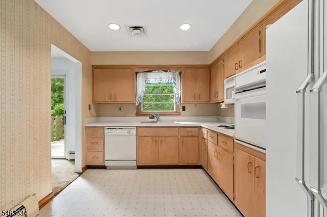 a kitchen with a sink window and cabinets